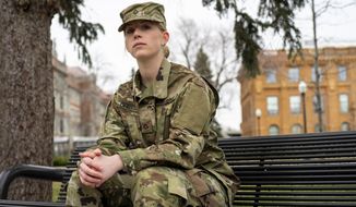 In this Friday, April 3, 2020, photo, senior Violet Ohnstad poses for a portrait on the University of Minnesota campus in Minneapolis. Ohnstad, who enlisted in the National Guard in January, is uncertain what the next few months will look like as she prepares for basic training. Ohnstad said she is excited to be a part of an organization that responds to crises like the coronavirus. (Jack Rodgers/The Minnesota Daily via AP)