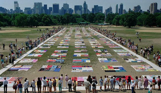 FILE - In this Saturday, June 25, 1988 file photo, people watch as almost 1,500 quilt panels bearing the names of New York area residents who have died of AIDS are unfolded on the Great Lawn in New York&#x27;s Central Park. The panels, which are expected to be incorporated into the national Names Project AIDS Quilt, include 75 bearing the names of metropolitan area infants. (AP Photo/Wilbur Funches, File)