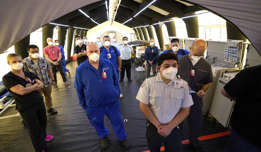 Medical workers listen to Harris County Judge Lina Hidalgo inside the intensive care unit during a tour of the new Harris County Non-Congregate Medical Shelter at NRG Park Saturday, April 11, 2020, in Houston. The new temporary setup will have 250 beds initially with a capacity of 2000 beds, if needed, to help relieve pressure on the hospital system from COVID-19 patients. Activation is not intended at this time. (AP Photo/David J. Phillip)