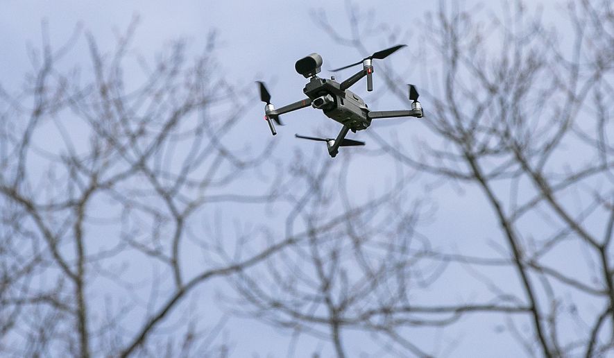 A drone operated by Sgt. Christian Rodriguez hovers at Hubbard Park in Meriden, Conn., Tuesday, April 14, 2020. The drone, which has a speaker attached, is being used to remind visitors to practice social distancing and limit their gatherings in public settings during the coronavirus pandemic. (Dave Zajac/Record-Journal via AP) ** FILE **