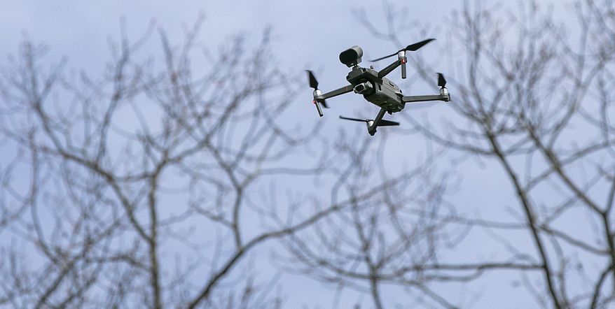 A drone operated by Sgt. Christian Rodriguez hovers at Hubbard Park in Meriden, Conn., Tuesday, April 14, 2020. The drone, which has a speaker attached, is being used to remind visitors to practice social distancing and limit their gatherings in public settings during the coronavirus pandemic. (Dave Zajac/Record-Journal via AP) ** FILE **
