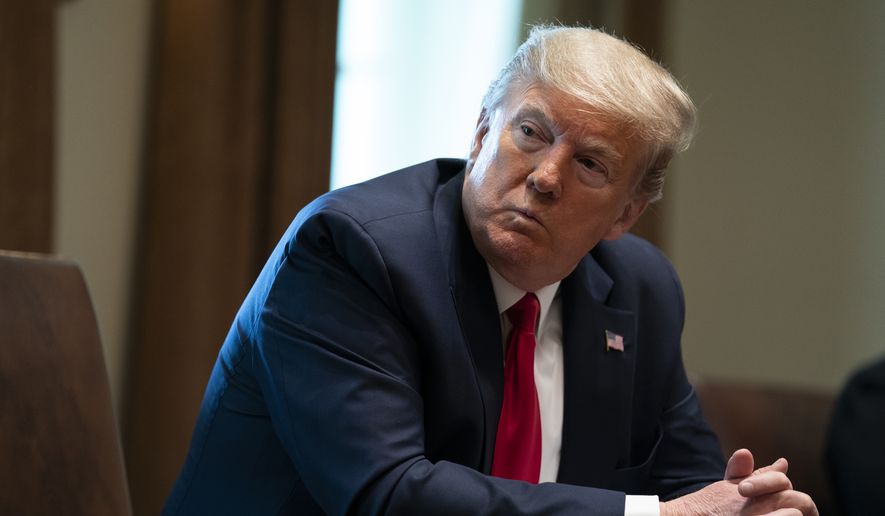 President Donald Trump listens during a meeting with people that have recovered from COVID-19, in the Cabinet Room of the White House, Tuesday, April 14, 2020, in Washington. (AP Photo/Evan Vucci)