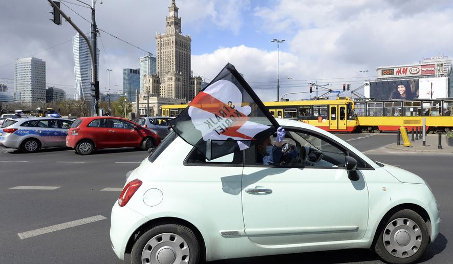 Women, self isolated in their cars to protect against coronavirus, take part in a protest against plans for the parliament to debate a draft law tightening Poland's ban on most abortions this week, in Warsaw, Poland, Tuesday, April 14, 2020. The new coronavirus causes mild or moderate symptoms for most people, but for some, especially older adults and people with existing health problems, it can cause more severe illness or death.(AP Photo/Czarek Sokolowski)