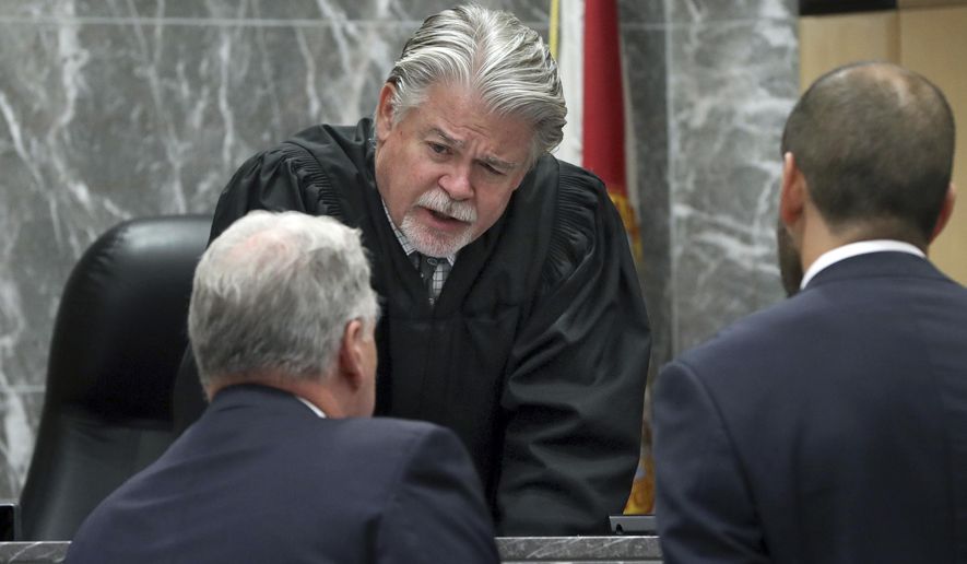 FILE - In this May 22, 2019 file photo, Broward Circuit Judge Dennis Bailey speaks to defense attorney Kevin Kulik in a sidebar discussion during closing arguments in the penalty phase of Pablo Ibar's trial at the Broward County Courthouse in Fort Lauderdale, Fla. Bailey is asking attorneys to get out of bed and put on some clothes when they show up for court hearings on Zoom after complaining to the Weston Bar Association that one male lawyer appeared shirtless and a female attorney was still in bed and under the covers. Broward County's courts are using the video conferencing site for hearings during the coronavirus pandemic. (Amy Beth Bennett/South Florida Sun Sentinel via AP, Pool, File)