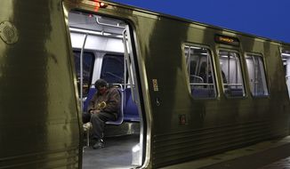 In this file photo, a man wears a face mask to protect against the spread of the new coronavirus as he sits on a Metro train, Wednesday, April 15, 2020, at the Ronald Reagan Washington National Airport Metro station in Arlington, Va.  (AP Photo/Patrick Semansky)  **FILE**