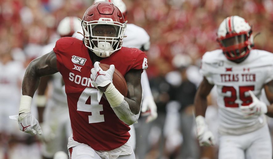 FILE - In this Sept. 28, 2019, file photo, Oklahoma running back Trey Sermon (4) carries for a touchdown in front of Texas Tech defensive back Dadrion Taylor (25) in the third quarter of an NCAA college football game in Norman, Okla. Ohio State coach Ryan Day said the addition of Oklahoma transfer running back Trey Sermon will give the Buckeyes a boost at a position that will be a question mark for going into fall training camp. (AP Photo/Sue Ogrocki, File)