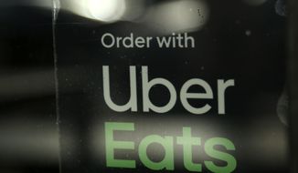 FILE - In this Nov. 6, 2019, file photo, a restaurant advertises Uber Eats in the Coconut Grove neighborhood in Miami. Some app-based delivery companies have announced hiring sprees to cope with a surge in orders from millions of people stuck at home during the coronavirus outbreak. Uber has an internal app that helps its ride-hailing drivers find work for Uber Eats and other jobs. (AP Photo/Lynne Sladky, File)