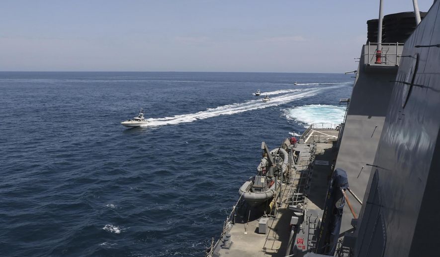 In this Wednesday, April 15, 2020, photo made available by U.S. Navy, Iranian Revolutionary Guard vessels sail close to U.S. military ships in the Persian Gulf near Kuwait. (U.S. Navy via AP) **FILE**