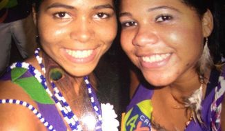 In this 2010 photo courtesy of Luana de Jesus Silva shows her with her sister Rafaela de Jesus Silva, left, in Salvador, Brazil, during Carnival celebrations. Rafaela de Jesus Silva gave birth on March 25, 2020, and then died a week later of coronavirus complications. (Luana de Jesus Silva via AP)