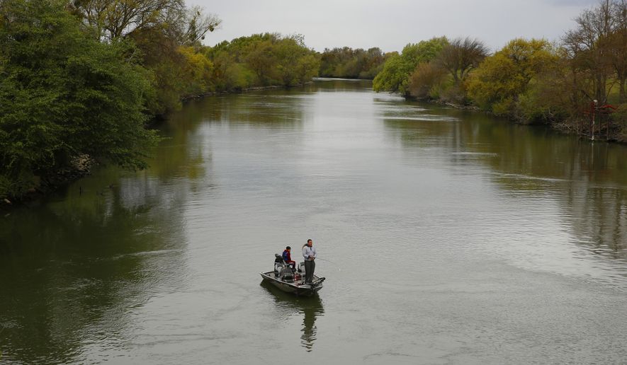 FILE - In this March 24, 2020, file photo, people fish in the Sacramento-San Joaquin River Delta's Elk Slough near Courtland, Calif. California regulators will try again to convene an online public meeting to discuss a potential limited ban on freshwater sport fishing amid the coronavirus pandemic after last week's teleconference was canceled when it became overwhelmed by hundreds of callers. The state Fish and Game Commission on Wednesday, April 15, will consider emergency closures of some California rivers, streams and lakes at the request of local officials concerned that visiting anglers might spread the virus. (AP Photo/Rich Pedroncelli, File)