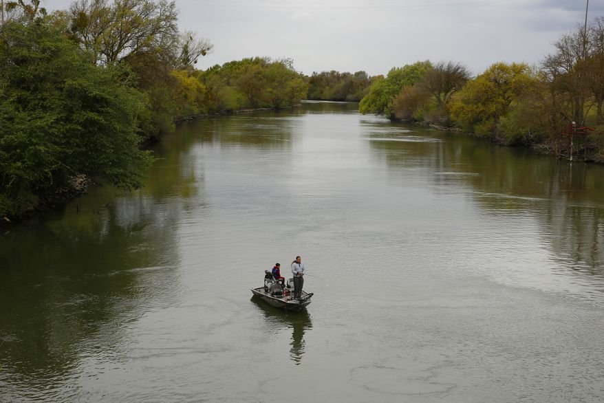 FILE - In this March 24, 2020, file photo, people fish in the Sacramento-San Joaquin River Delta's Elk Slough near Courtland, Calif. California regulators will try again to convene an online public meeting to discuss a potential limited ban on freshwater sport fishing amid the coronavirus pandemic after last week's teleconference was canceled when it became overwhelmed by hundreds of callers. The state Fish and Game Commission on Wednesday, April 15, will consider emergency closures of some California rivers, streams and lakes at the request of local officials concerned that visiting anglers might spread the virus. (AP Photo/Rich Pedroncelli, File)