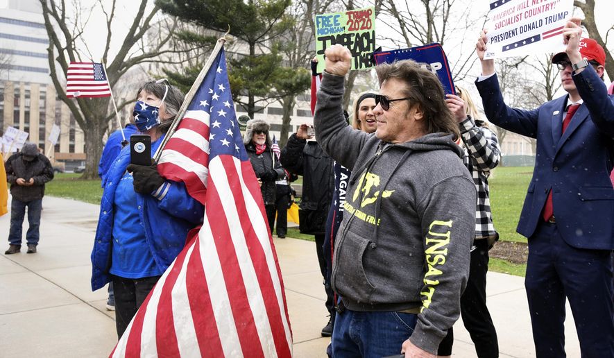 Rallygoers protest against Michigan Gov. Gretchen Whitmer&#39;s stay-at-home order at the state Capitol on Wednesday, April 15, 2020, in downtown Lansing, Mich. (Matthew Dae Smith/Lansing State Journal via AP)