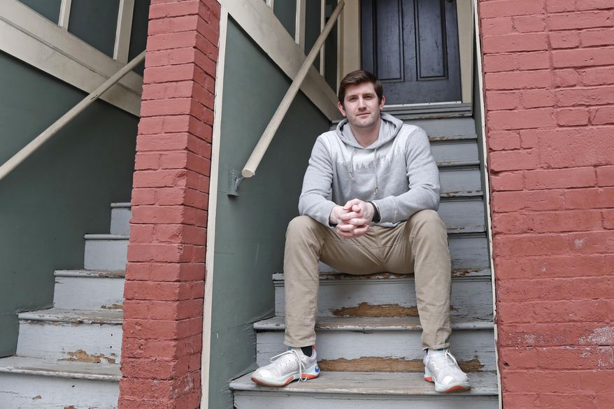 Cameron Karosis, 27, a software salesman, poses for a portrait outside his home, Tuesday, April 14, 2020, in Cambridge, Mass. Karosis usually strives to protect his personal information. But a scary bout with COVID-19 that began with headaches and fevers, progressed to breathing problems and led to a hospital visit has now left him eager to disclose as much as possible to help halt the virus' spread. “I’m sick and I’m under a quarantine -- hold me accountable for it,” he said. “You have the potential to kill other people.” (AP Photo/Elise Amendola)