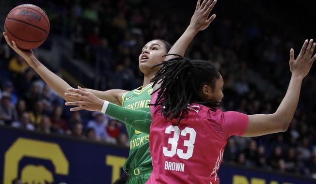 FILE - In this Feb. 21, 2020, file photo, Oregon&#x27;s Satou Sabally, left, shoots past California&#x27;s Jaelyn Brown (33) in the first half of an NCAA college basketball game in Berkeley, Calif. The Associated Press had a panel of WNBA coaches and general managers hold a mock draft. (AP Photo/Ben Margot, File)