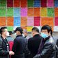In this April 8, 2020 photo, laborers wear facemasks to protect against the spread of the new coronavirus as they look at job postings at a labor market in Qingdao in eastern China&#39;s Shandong Province. China has reported its biggest economic decline since the 1970s as it fought the coronavirus in the first quarter of the year. (Chinatopix via AP)