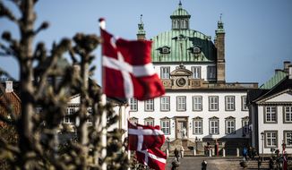 National flags are raised outside Fredensborg Castle, in Fredensborg, Denmark, Thursday, April 16, 2020. The Danish Queen Margrethe is celebrating her 80th birthday today but in private due to the new COVID-19 coronavirus pandemic. (Olafur Steinar Gestsson/Ritzau Scanpix via AP)