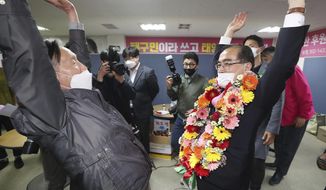 Thae Yong-ho, right, former North Korean diplomat, who defected to South Korea in 2016 and a candidate of the main opposition United Future Party, reacts with a supporter after he was certain to secure victory in the parliamentary election in Seoul, South Korea, Thursday, April 16, 2020. Thae on Thursday won a constituency seat in South Korea’s parliamentary elections, the first such achievement among tens of thousands of North Koreans who have fled their authoritarian, impoverished homeland. (Shin Jun-hee/Yonhap via AP)