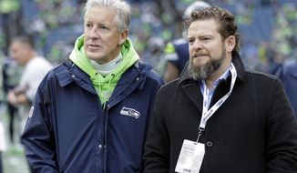 FILE - In this Dec. 30, 2018, file photo, Seattle Seahawks coach Pete Carroll, left, talks with general manager John Schneider before  the team&#39;s NFL football game against the Arizona Cardinals in Seattle. There is a clear and obvious need for the Seahawks to address along the defensive line and it happens to be one of the deeper positions of talent in the entire draft. That may be far too simplistic and straightforward for Schneider and Carroll. Schneider is always good for a few surprises in the draft, and more than a couple of trades.  So, while it seems addressing the pass rush — especially with the continuing unknowns around Jadeveon Clowney — is the obvious direction for Schneider and the Seahawks, it’s never that clear with Seattle. (AP Photo/Ted S. Warren, File)