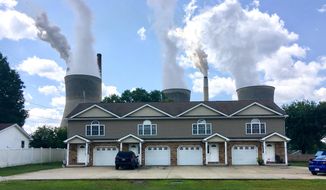 In this Aug. 23, 2018, file photo, a coal-fired plant in Winfield, W.Va, is seen from an apartment complex in the town of Poca across the Kanawha River. The Trump administration is gutting an Obama-era rule that compelled coal plants to cut back emissions of mercury and other human health hazards, limiting future regulation of air pollutants by petroleum and coal plants. (AP Photo/John Raby, File)