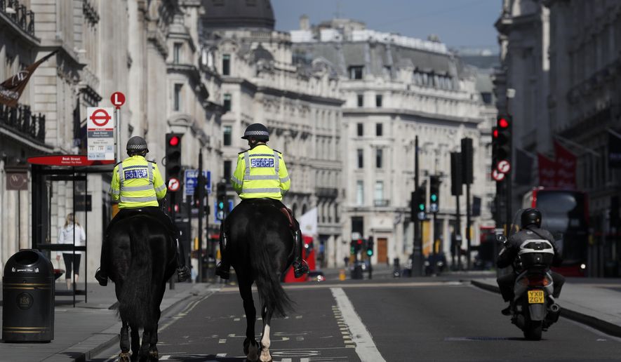 Mounted police officers patrol along a deserted Regent Street in London, as the country is in lockdown to help curb the spread of the coronavirus, Wednesday, April 15, 2020. Experts in the UK have warned that the economy could shrink by up to 35% as a knock on effect of the lockdown. The highly contagious COVID-19 coronavirus has impacted on nations around the globe, many imposing self isolation and exercising social distancing when people move from their homes. (AP Photo/Frank Augstein)