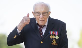 99-year-old war veteran Captain Tom Moore, poses for a photo at his home in Marston Moretaine, England, after he achieved his goal of 100 laps of his garden, raising millions of pounds for the NHS with donations to his fundraising challenge from around the world, Thursday April 16, 2020. Moore started walking laps in his garden as a humble fundraising challenge to walk 100 lengths of his garden by his 100th birthday on April 30, and has now raised millions for the National Health Service and become a national rallying point during the COVID-19 coronavirus pandemic.  His family thought it would be a stretch to raise 1,000 pounds, but donors have pledged millions of pounds and still counting. (Joe Giddens/PA via AP)
