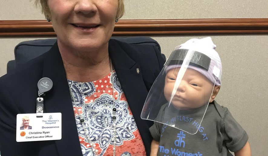 In this April 14, 2020, photograph provided by Deaconess Women's Hospital, in Evansville, Ind., an infant recently delivered at the hospital and identified only as "Baby Brooklyn" by hospital officials, wears a plastic face shield as a protection against COVID-19. The scaled-down face shields are being produced by Evansville-based plastic packaging manufacturer Berry Global to protect infants from the coronavirus. As of Wednesday, April 15, 2020, the hospital said it had begun using about 10 of the shields on infants. (Lindsey Johnson/Deaconess Women's Hospital via AP)