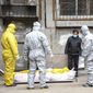 Funeral home workers remove the body of a person suspected to have died from the coronavirus outbreak from a residential building in Wuhan in central China&#39;s Hubei Province,&quot; Feb 1, 2020. The central Chinese city of Wuhan has raised its number of COVID-19 fatalities by more than 1,000. State media said the undercount had been due to the insufficient admission capabilities at overwhelmed medical facilities at the peak of the outbreak. (Chinatopix via AP) ** FILE ** 