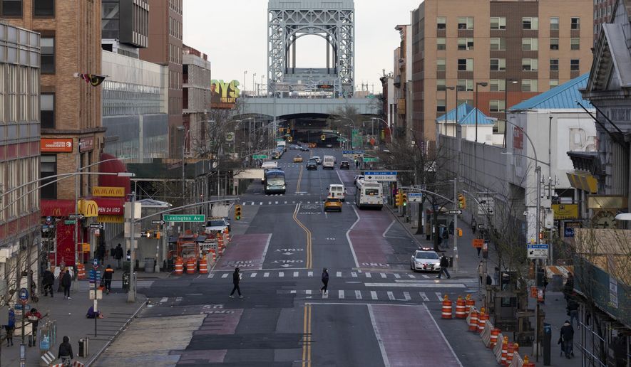 There is little traffic on 125th Street, Thursday, April 16, 2020, in the Harlem neighborhood of New York during the coronavirus pandemic. Gov. Andrew Cuomo extended stay-at-home restrictions Thursday through mid-May. (AP Photo/Mark Lennihan)