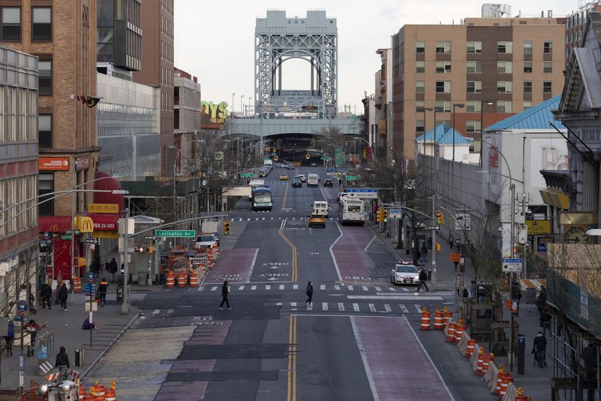 There is little traffic on 125th Street, Thursday, April 16, 2020, in the Harlem neighborhood of New York during the coronavirus pandemic. Gov. Andrew Cuomo extended stay-at-home restrictions Thursday through mid-May. (AP Photo/Mark Lennihan)