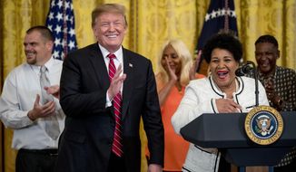 In this April 1, 2019, file photo, President Donald Trump reacts as Alice Marie Johnson speaks at the 2019 Prison Reform Summit and First Step Act Celebration in the East Room of the White House in Washington. The 64-year-old African American great-grandmother spent 21 years in prison for a nonviolent drug offense before Trump commuted her sentence in 2018. (AP Photo/Andrew Harnik, File)