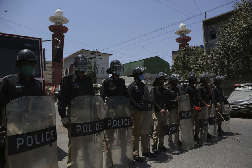 Police officers stand guard outside a mosque during a nation-wide lock down as a preventive measure against the outbreak of coronavirus, in Karachi, Pakistan, Friday, April 17, 2020. (AP Photo/Fareed Khan)