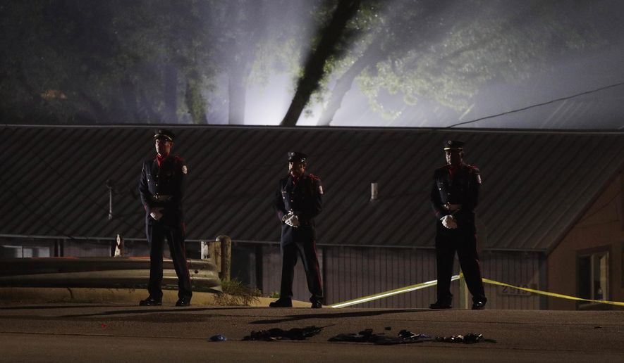 Members of an honor guard stand at the scene where a man shot and killed a San Marcos police officer and wounded a few others, Saturday, April 18, 2020, in San Marcos, Texas. A gunman shot and killed a Texas police officer and wounded two others Saturday after they responded to a call at an apartment complex, authorities said. (AP Photo/Eric Gay)