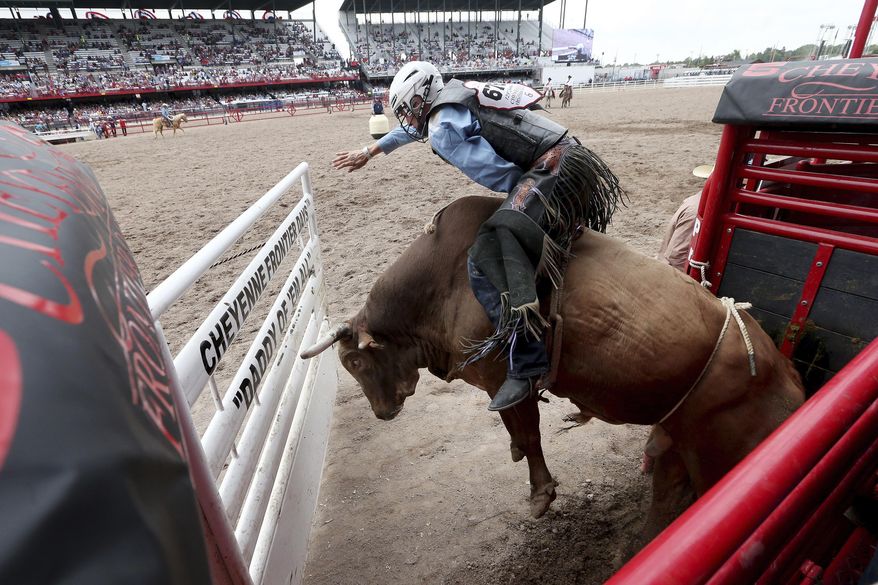 FILE - In this July 22, 2019, file photo, J.T. Moore, of Alvin, Texas, competes in bull riding at Frontier Park Arena in Cheyenne, Wy., during the Cheyenne Frontier Days event. The Cheyenne Frontier Days has been held for 123 straight years. The organizers are holding out hope the event scheduled for July won't be interrupted by the new coronavirus. It's a financial bonanza for the capital city situated in the southeast corner of Wyoming. The 10-day event drew more than 262,000 spectators last year. (Michael Cummo/Wyoming Tribune Eagle via AP, File)