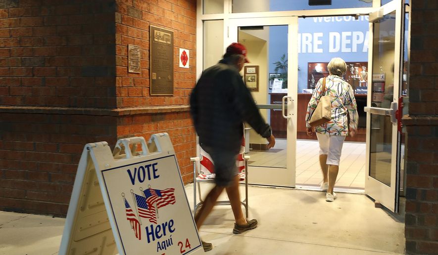 In this March 17, 2020, file photo voters walk into a polling station for the Florida presidential primary in Bonita Springs, Fla. Scrambling to address voting concerns amid a pandemic, election officials from Nevada to Florida are scaling back or eliminating opportunities for people to cast ballots in person. (AP Photo/Elise Amendola, File)