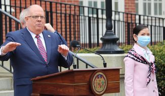 Maryland Gov. Larry Hogan speaks at a news conference on Monday, April 20, 2020 in Annapolis, Md., with his wife, Yumi Hogan, right, where the governor announced Maryland has received a shipment from a South Korean company to boost the state's ability to conduct tests for COVID-19 by 500,000. Hogan said he asked his wife, who is Korean, to help negotiate with Korean officials, on March 28, and that set in motion 22 days of vetting and negotiations to bring the large increase in testing capacity to Maryland. (AP Photo/Brian Witte)