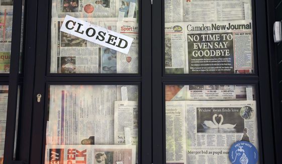 A front page of the Camden New Journal newspaper with a coronavirus related headline hangs stuck with other pages on the closed doors of a restaurant, unable to open due to the coronavirus lockdown, in central London, Monday, April 20, 2020. The highly contagious COVID-19 coronavirus has impacted on nations around the globe, many imposing self isolation and exercising social distancing when people move from their homes. (AP Photo/Matt Dunham)