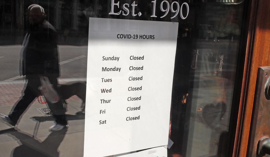 A sign on the front door of a culinary store lists their &amp;quot;COVID-19&amp;quot; business hours, with every day shown as closed, in Concord, N.H., Monday, April 20, 2020. All non-essential businesses are closed due to the virus outbreak were until May 4th. (AP Photo/Charles Krupa)