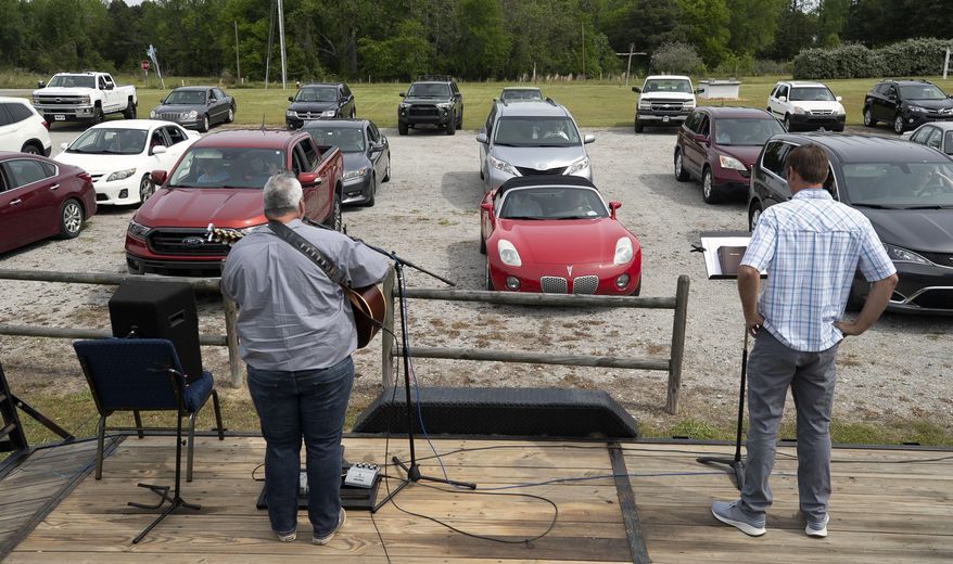 LifePoint Community Church worship pastor Troy Bullard, left, and pastor Nathan Redinger lead a drive-in worship service on Sunday, April 19, 2020, in Willow Spring, N.C., during the coronavirus outbreak. (Robert Willett/The News & Observer via AP)