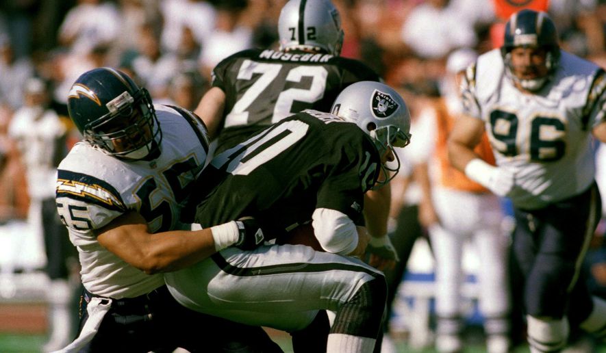 FILE - In this Dec. 20, 1992, file photo, Los Angeles Raiders quarterback Jay Schroeder is sacked for a 5-yard loss by San Diego Charger inside linebacker Junior Seau (55) during the second quarter of an NFL football game in Los Angeles. San Diego went for the hometown pick in 1990, selecting Oceanside native and Southern California standout Seau fifth overall. He ended up becoming one of the most popular players in franchise history with 12 consecutive Pro Bowl appearances. (AP Photo/Mark Terrill, File)