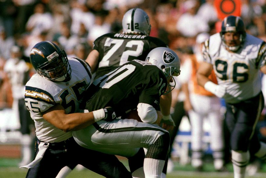FILE - In this Dec. 20, 1992, file photo, Los Angeles Raiders quarterback Jay Schroeder is sacked for a 5-yard loss by San Diego Charger inside linebacker Junior Seau (55) during the second quarter of an NFL football game in Los Angeles. San Diego went for the hometown pick in 1990, selecting Oceanside native and Southern California standout Seau fifth overall. He ended up becoming one of the most popular players in franchise history with 12 consecutive Pro Bowl appearances. (AP Photo/Mark Terrill, File)
