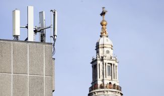 In this Tuesday, Jan 28, 2020, file photo, mobile network phone masts are visible in front of St Paul's Cathedral in the City of London. Dozens of European cell towers have been destroyed in recent arson attacks that officials and wireless companies say are fueled by groundless conspiracy theories linking new 5G mobile networks and the coronavirus pandemic. (AP Photo/Alastair Grant, File)