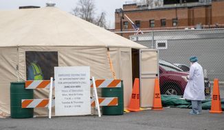 A medic waits outside a tent for her turn to be tested for COVID-19 at Queens Hospital Center, Monday, April 20, 2020, in the Jamaica neighborhood of the Queens borough of New York. The new coronavirus causes mild or moderate symptoms for most people, but for some, especially older adults and people with existing health problems, it can cause more severe illness or death. (AP Photo/Mary Altaffer)