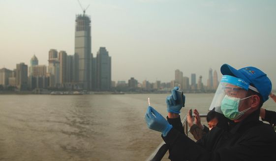 In this April 8, 2020, photo, Chen Enting, 34, snaps a photo of his ticket to commemorate his first ferry ride across the Yangtze River in Wuhan in central China&#39;s Hubei province after a 76-day quarantine ended in the city at the center of the coronavirus pandemic. The reopening of the ferry service on the Yangtze, the heart of life in Wuhan for more than 20 centuries, was an important symbolic step in official efforts to get business and daily life in this central Chinese city of 11 million people back to normal. (AP Photo/Sam McNeil)