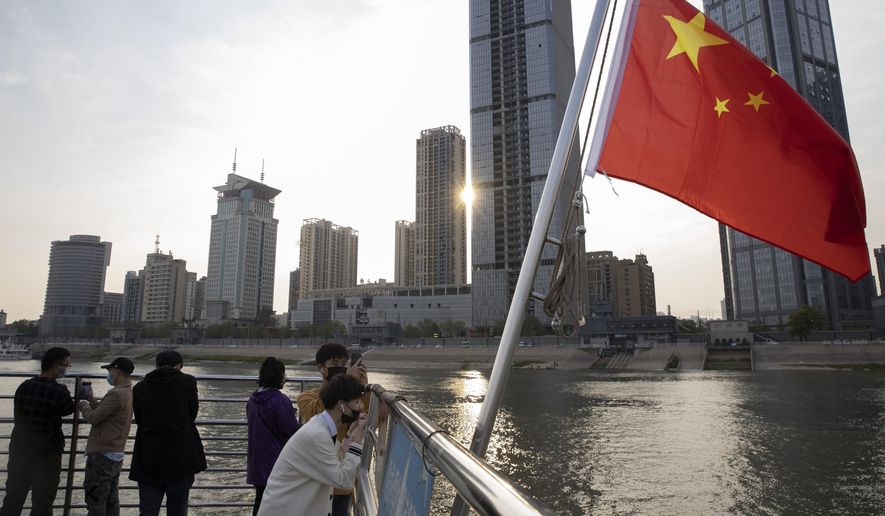 In this April 8, 2020, photo, passengers cross the Yangtze River on a ferry in Wuhan in central China's Hubei province. The reopening of ferry service on the Yangtze River, the heart of life in Wuhan for more than 20 centuries, was an important symbolic step in official efforts to get business and daily life in this central Chinese city of 11 million people back to normal after a 76-day quarantine ended in the city at the center of the coronavirus pandemic. (AP Photo/Ng Han Guan)