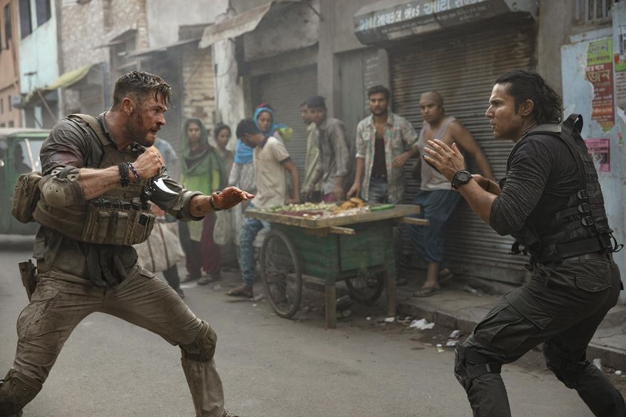 This image released by Netflix shows Chris Hemsworth, left, in a scene from &amp;quot;Extraction,&amp;quot; premiering this week on Netflix. (Jasin Boland/Netflix via AP)