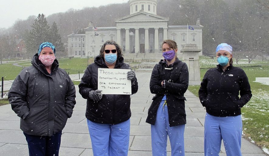 Nurses from Central Vermont Medical Center stand on the Statehouse lawn, Wednesday, April 22, 2020, in Montpelier, Vt., to counter a protest by a small group against Vermont's stay-at-home order. (AP Photo/Lisa Rathke)