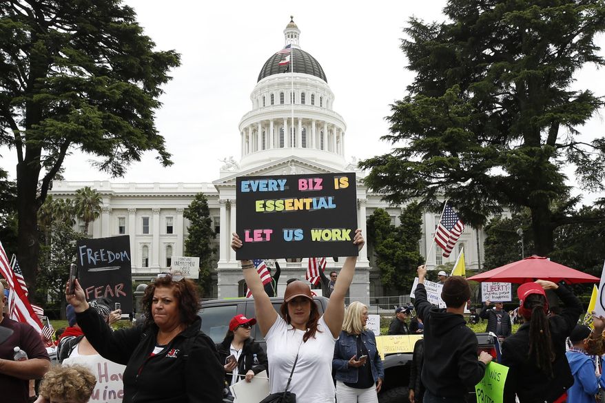 In this Monday, April 20, 2020, file photo, protesters calling for an end of Gov. Gavin Newsom's stay-at-home orders rally at the state Capitol in Sacramento, Calif. The California Highway Patrol announced Wednesday, April 22, 2020, that it is temporarily banning rallies at the state Capitol and other state facilities due to the pandemic. The change came after hundreds of protestors gathered on the Capitol grounds Monday, many without masks or following recommendations to remain six feet apart to slow the spread of the coronavirus. (AP Photo/Rich Pedroncelli, File)