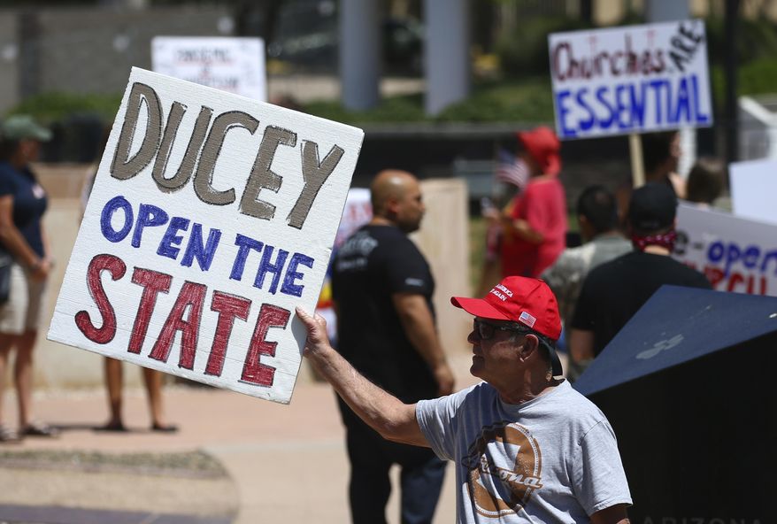In this April 20, 2020, photo, protesters rally at the state Capitol to 're-open' Arizona against the governor's stay-at-home order due to the coronavirus in Phoenix. (AP Photo/Ross D. Franklin) **FILE**