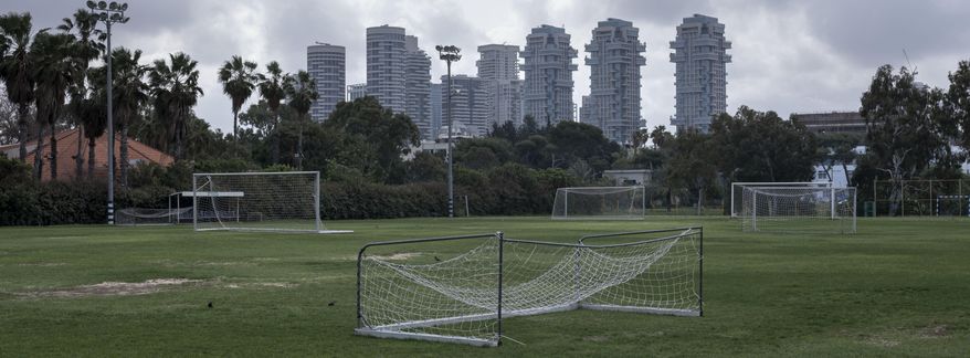 In this Saturday, March 28, 2020 photo, a closed training soccer field is seen during lockdown following government measures to help stop the spread of the coronavirus in Tel Aviv, Israel. The once thrumming city of Tel Aviv, famed for its nightlife and bustling beachfront, has fallen eerily quiet due to Israel's tight movement restrictions to halt the spread of the coronavirus. (AP Photo/Oded Balilty)