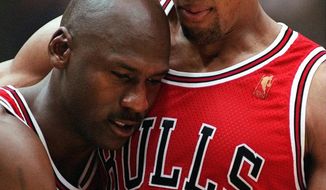 In this June 11, 1997 file photo, Chicago Bulls Scottie Pippen, right, embraces an exhausted Michael Jordan following their win in Game 5 of the NBA Finals against the Utah Jazz, in Salt Lake City. The flu-like illness Jordan fought through to lead the Bulls to a crucial victory in the 1997 NBA Finals created instant fodder for the virtue of perseverance. Pushing past boundaries, overcoming obstacles and adversity —  that is part of the ethos of major competitive sports. That is how elite athletes become wired to win. (AP Photo/Jack Smith) ** FILE **